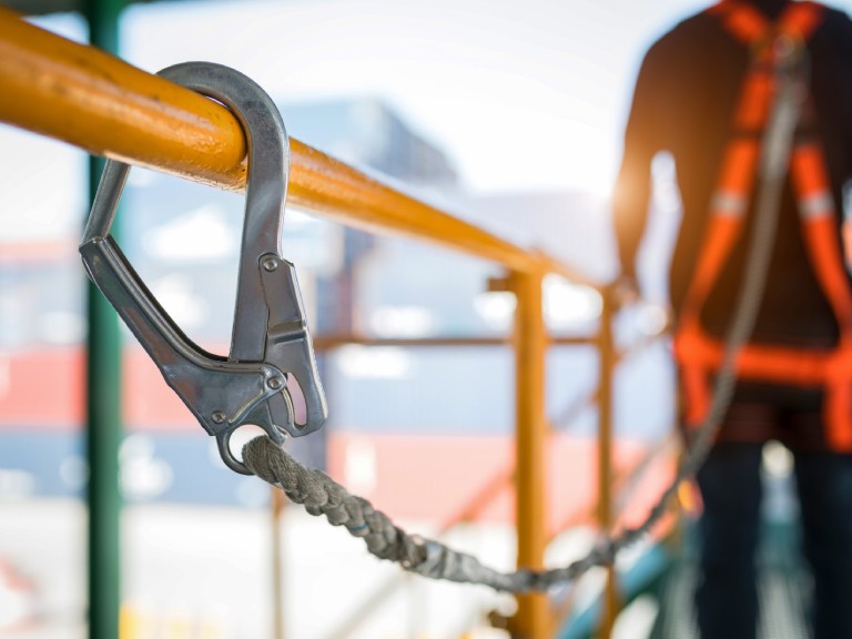 Construction worker standing on scaffolding with fall arrest equipment